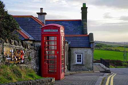 green and brown concrete house near on red telephone boot thumbnail