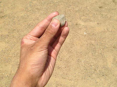 person holding brown rock thumbnail