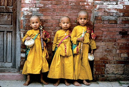 three children wearing yellow traditional dresses thumbnail