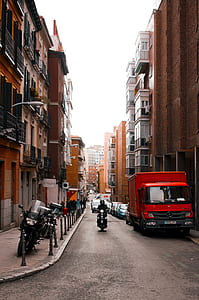man riding motorcycle between building thumbnail
