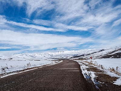 brown road near field covered with snow under white clouds during daytime thumbnail