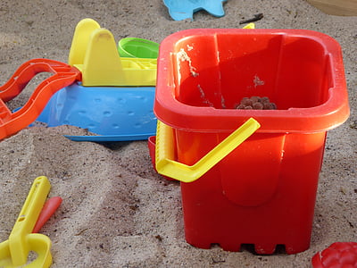 red plastic bucket on sand thumbnail