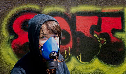person wearing gas mask beside wall thumbnail