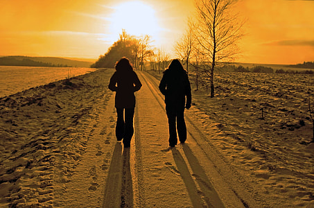 silhouette of 2 person walking towards the sunset thumbnail