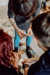Women folding sheet of paper while making origami thumbnail