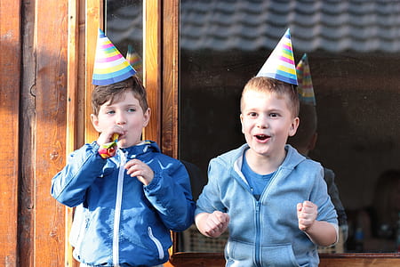 two boys wearing jackets and party cones thumbnail