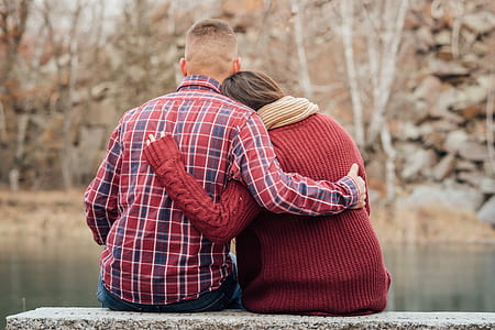 man holding back of woman near body of water thumbnail