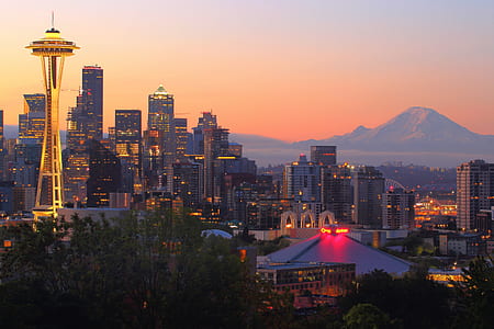 assorted tower buildings near mountain under sunset thumbnail