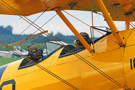 two men on yellow aircraft during daytime thumbnail