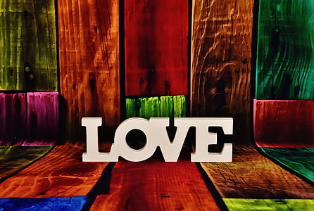 white LOVE freestanding letters on multicolored wood planks thumbnail