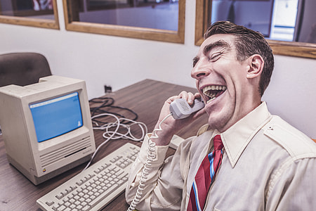 man in gray dress shirt holding telephone thumbnail