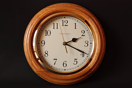 round brown analog wall clock on black surface thumbnail