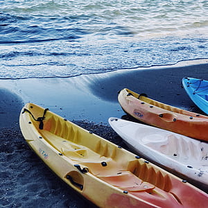 closeup photography of four kayaks in line on seashore thumbnail