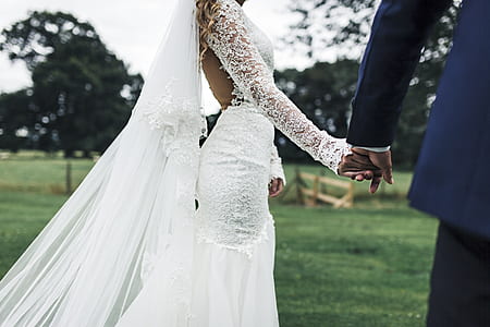 woman in white wedding gown beside man in blue dress suit outfit thumbnail