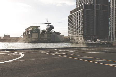 black helicopter near helipad during daytime thumbnail