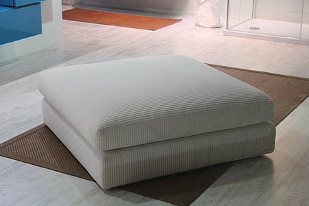 white fabric ottoman on floor thumbnail