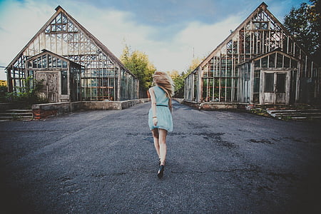 woman wearing blue dress walking through building thumbnail
