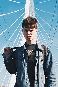 man wearing blue denim jacket standing thumbnail