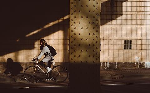 woman riding on bicycle near brown post thumbnail