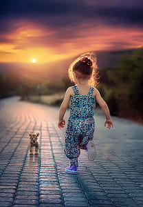 girl wearing blue and black leopard pattern overalls running toward leopard cub thumbnail