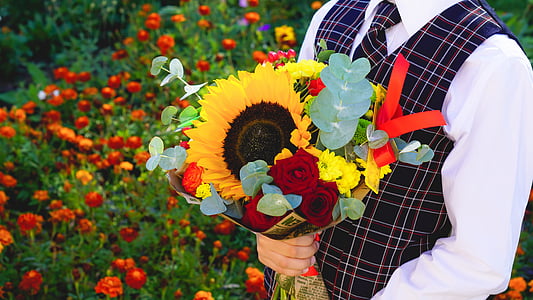 man holding assorted-color flower bouquet thumbnail