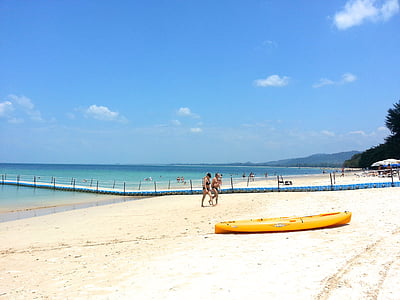 yellow kayak on beach near people walking thumbnail