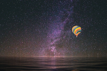 multicolored hot air balloon sailing during nighttime thumbnail