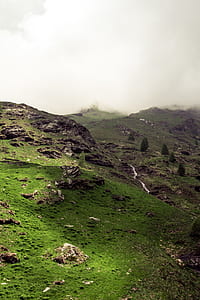 mountains covered with green grasses and trees under cloudy sky during daytime thumbnail