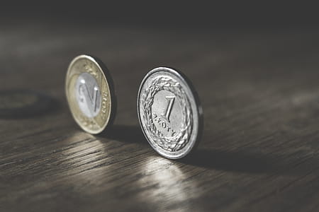 Photo of Two Gold-colored and Silver-colored Coins Standing on Floor thumbnail