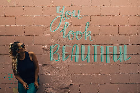 Woman Standing in Beige Concrete Block With You Look Beautiful Paint thumbnail