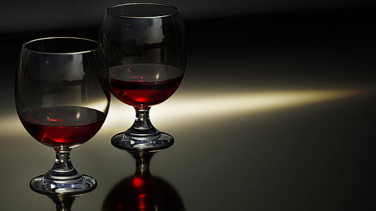 two wine glasses filled with red wine thumbnail