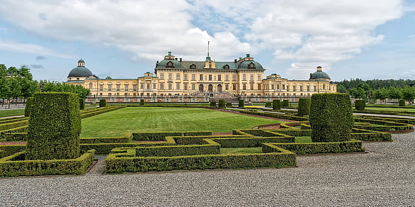 palace surrounded with green grass field thumbnail
