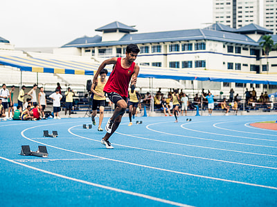 men racing on track and field at daytime thumbnail