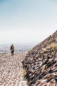 A man carrying a backpack walking on historic stone tomb thumbnail