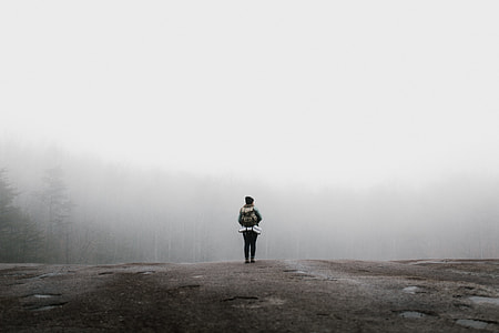 person standing on ledge covered by fog thumbnail