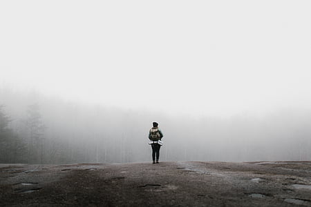 woman standing on cliff in front of fog covered forest thumbnail