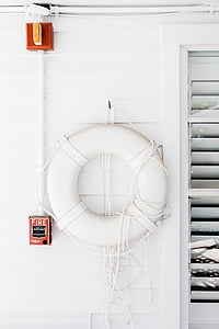 white swim ring hanging on white painted wall beside red and black fire button thumbnail
