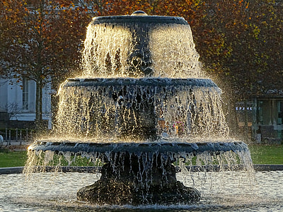 black 3-tier outdoor fountain near brown leaf tress during daytime thumbnail