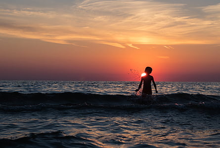 silhouette photography of kid on body of water thumbnail