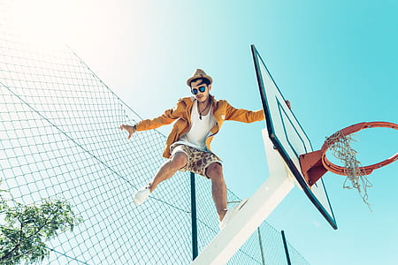 man standing on black and white basketball hoop thumbnail