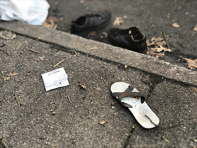 unpaired gray sandal on pavement thumbnail