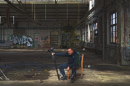 man sitting on chair holding camera thumbnail