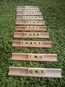 scrabble tiles on racks on green textile thumbnail