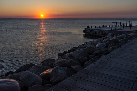 Sunset over the ocean at the shore and docks in Malmo, Sweden thumbnail