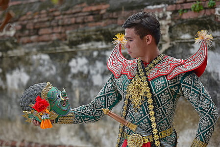 man with costume holding mask during daytime thumbnail