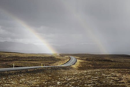 gray concrete roadway between of brown field at daytime thumbnail