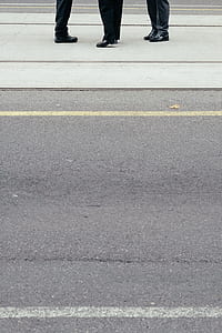 three person stepping on concrete floor near asphalt road thumbnail