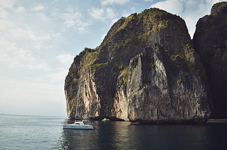 White Sailing Boat Beside Mountain thumbnail