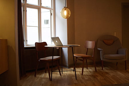 silver MacBook on top of brown table near window thumbnail
