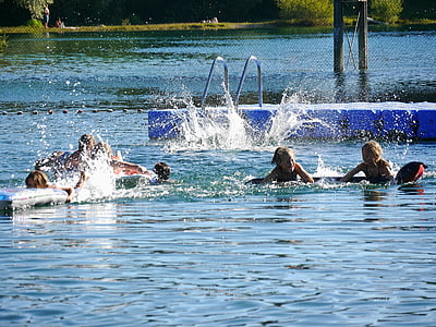 people swimming on body of water thumbnail